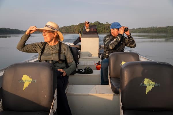 SouthWild Amazon Lodge, Female tourist on boat with field guide in amazon rainforest Juruena River
