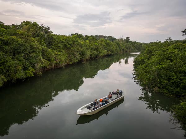 SouthWild Amazon Lodge, Beautiful aerial view to small tour boat on wild green Juruena amazon rainforest river