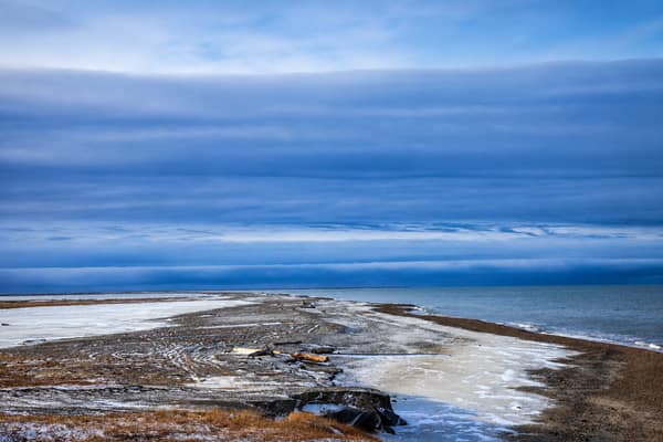 Calm Arctic sea and low tundra shoreline along the Beaufort Sea coast