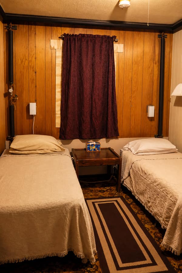 A wood-paneled twin-bed guest room at Waldo Arms