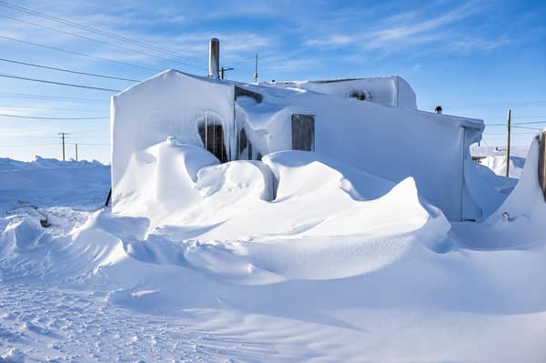 Houses buried in windblown snowdrifts in Kaktovik
