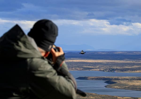 A photographer capturing a condor in flight over the steppe