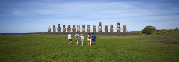 Travelers approaching the row of fifteen moai at Ahu Tongariki