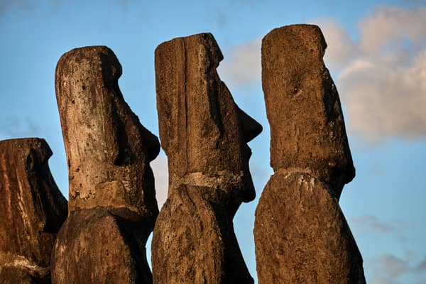 Weathered moai heads in profile against the sky