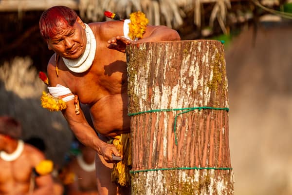 Preparing a decorated ceremonial log in the village