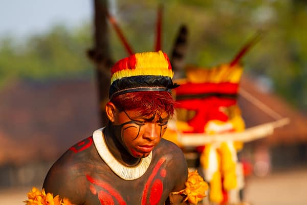 A young man in a feather headdress and body paint during a ceremony